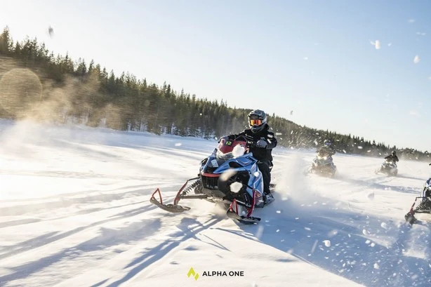 Schneemobilfahrer im Sonnenlicht in Lappland