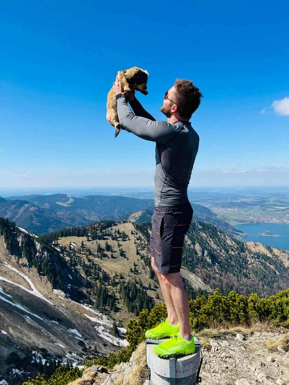 Sebastian holding Rosi above a mountain summit